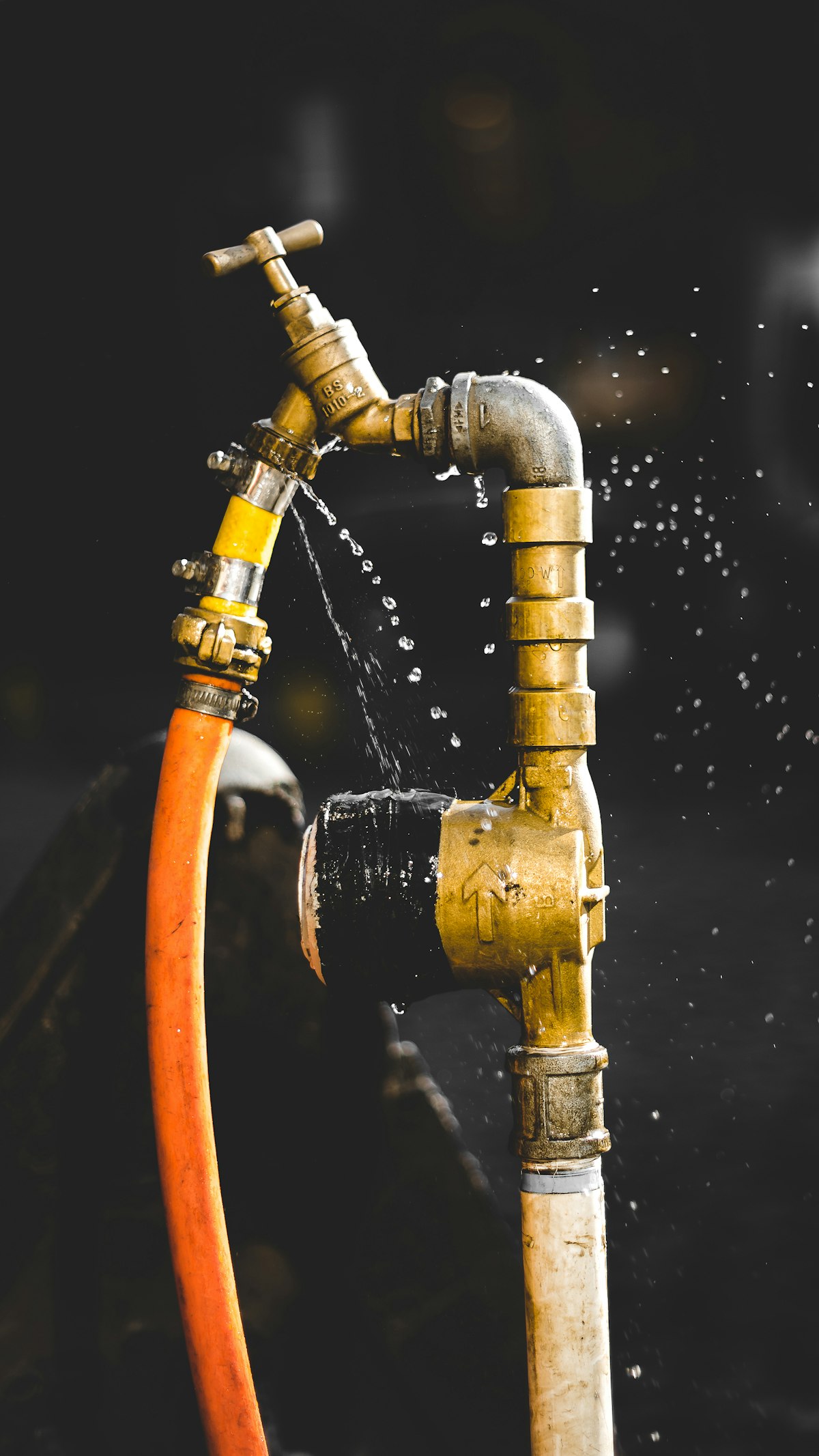 Water spraying from a leaking brass pipe fitting